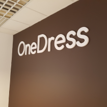 One Dress logotipas ant sienos pagamintas iš PVC plastiko.
